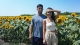 Moldova, Farmer Cristina Bejereanu and her husband in a sunflower field