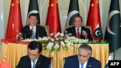 Chinese President Xi Jinping (top-L) and Pakistan's Prime Minister Nawaz Sharif (top-R) look on as Pakistani Finance Minister Ishaq Dar (R) and a Chinese official (L) signing an MoU at Prime Minister's House in Islamabad, April 20.