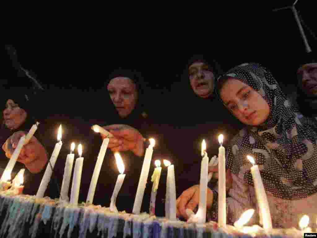 Iraqis light candles as they take part in a Shi'ite ritual in Karbala, south of Baghdad, on July 27. Thousands of pilgrims commemorated the birth of the 12th Imam Al-Mahdi, a Messiah-like figure revered by Shi'ite Muslims, who believe he disappeared centuries ago but never died. Photo by Mushtaq Muhammad for Reuters