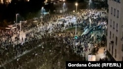 Serbian security personnel and protesters gather in front of the Serbian Parliament building on March 15.