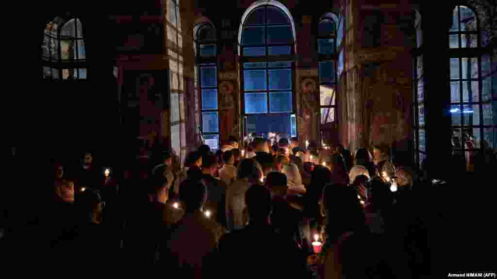 Pravoslavni vjernici pale svijeće dok učestvuju u ponoćnoj liturgiji u manastiru Gračanica, nedaleko od Prištine, 12. aprila.