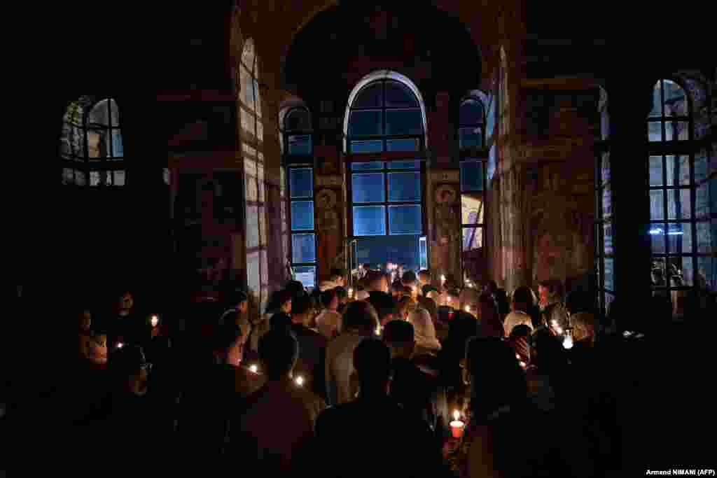 Besimtarët ortodoksë ndezin qirinj teksa marrin pjesë në meshën e mesnatës në manastirin e Graçanicës, afër Prishtinës më 12 prill.