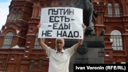 Активист Владимир Ионов во время одиночного пикета держит плакат с надписью: "Путин есть - еды не надо". Москва, 15 августа 2015 года.