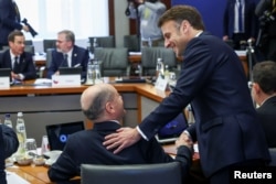 Președintele francez Emmanuel Macron îl salută pe cancelarul german Olaf Scholz la summitul informal al liderilor europeni, 3 februarie.