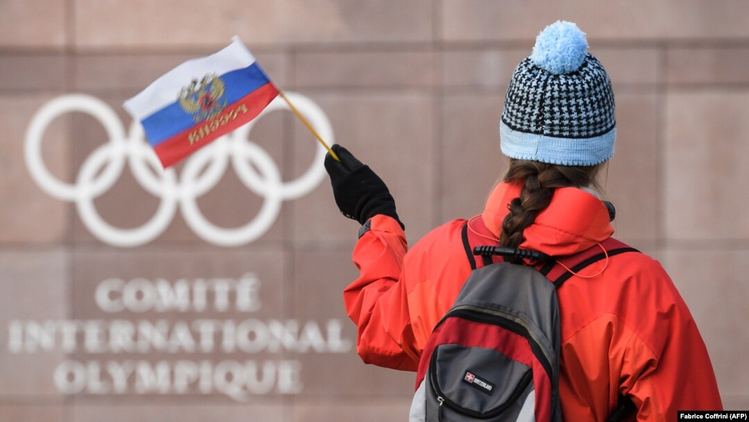 A supporter waves a Russian flag in front of the logo of the International Olympic Committee at their headquarters near Lausanne. (file photo)
