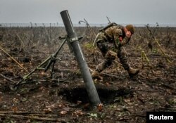 Un militar ucrainean trage cu un mortier pe linia frontului din regiunea Zaporojie, Ucraina, 16 noiembrie 2022.