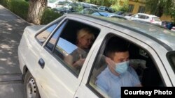 Полицейские увозят активистку Санавар Закирову (на заднем сиденье машины) из дома в СИЗО после обвинительного приговора, по которому она осуждена на год лишения свободы. Алматы, 15 июля 2020 года.