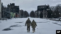 Soldați ucraineni pe o stradă din orașul asediat Bahmut, la 12 februarie.