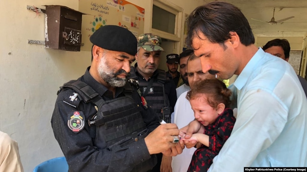 Police in Khyber Pakhtunkhwa Province's Bajaur district take part in vaccinating children again polio in September. 