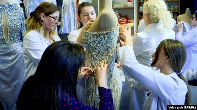 Punëtoret e Walone Fashion Group duke punuar një fustan nusërie.