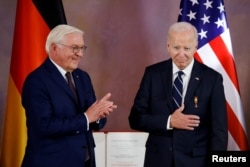 Joe Biden, purtând cea mai înaltă distincție a Germaniei - Marea Cruce a Ordinului de Merit - care i-a fost oferită „pentru merite deosebite” de către președintele Frank-Walter Steinmeier.