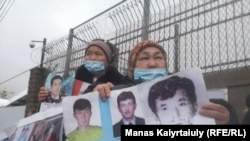 Участницы пикета перед консульством Китая в Алматы держат в руках фото своих родственников, по их словам, удерживаемых или отправленных в тюрьмы в Синьцзяне по необоснованным обвинениям. Алматы, 11 марта 2021 года.