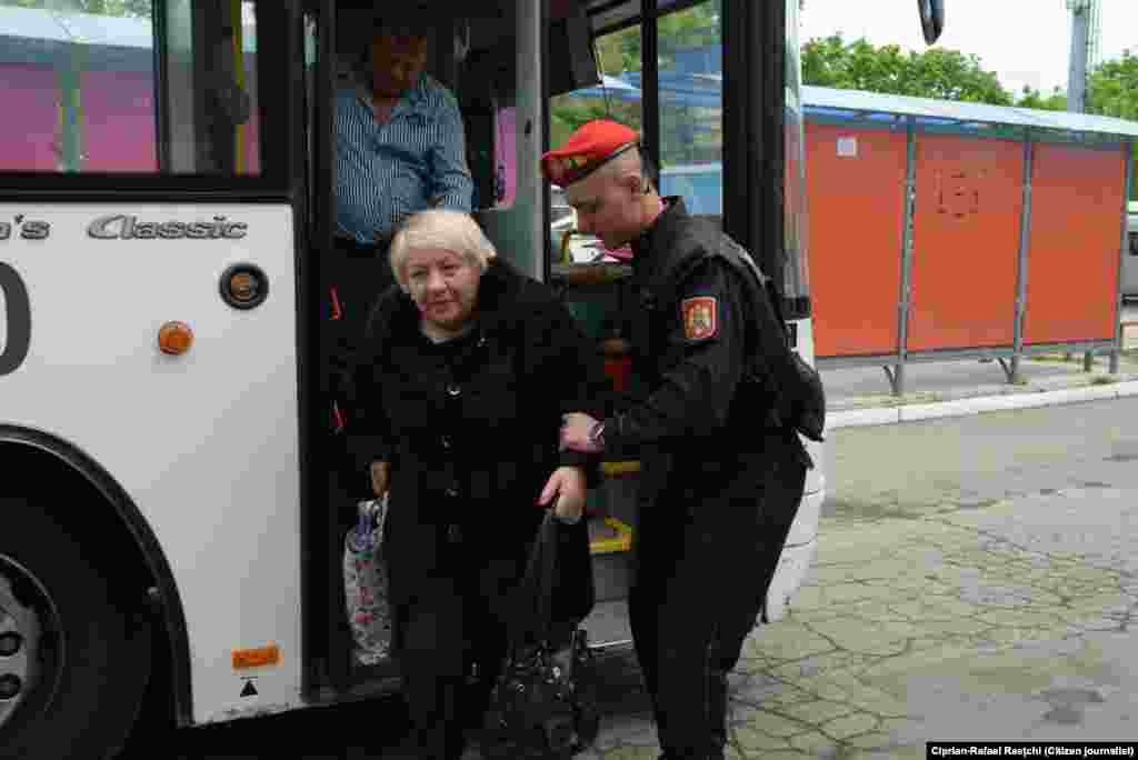 19. Un polițist ajută o doamnă în vârstă să coboare din autobuz. (Foto: Ciprian-Rafael Raețchi)