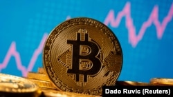 A representation of virtual currency Bitcoin is seen in front of a stock graph in this illustration taken November 19, 2020
