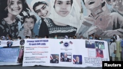 Afghan interpreters, who worked with U.S. troops, hold signs during a demonstration about their safety in front of the U.S. Embassy in Kabul.