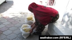 Turkmenistan. Turkmen woman selling corn. National clothes. Ashgabat. June 26, 2014