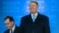 Romanian President Klaus Iohannis (right) and Prime Minister Ludovic Orban greet supporters after announcing the results of the presidential election in Bucharest on November 24. 