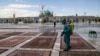 Workers disinfecting rugs from Masoumeh Shrine in Qom. June 17, 2020. 