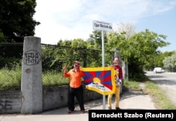 Activists hold a Tibetan flag on a street renamed Uyghur Martyrs' Road, near the planned site of the Fudan University campus, in Budapest on June 2.