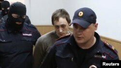 Bolshoi Theater dancer Pavel Dmitrichenko (center) is escorted to a court session in Moscow on October 16.