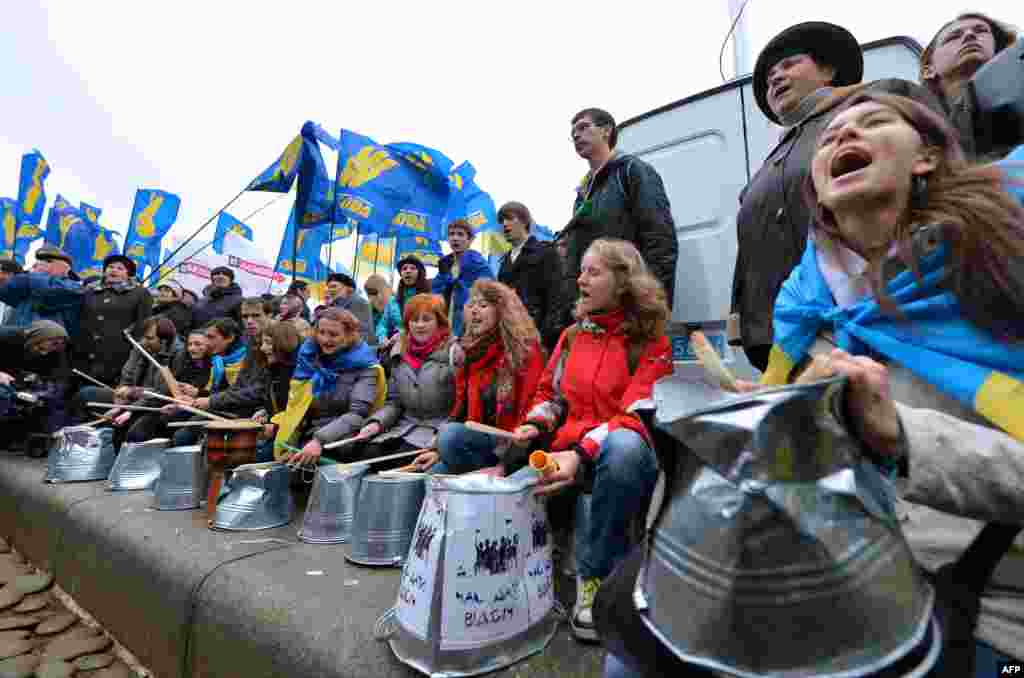 Protesters shout slogans and use buckets as drums.