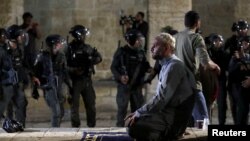 Palestinac se moli ispred džamije Al-Aqsa u Jerusalimu dok traju sukobi izraelske policije sa demonstrantima, 7. maj