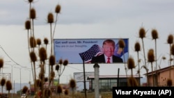 A giant billboard depicting U.S. President Donald Trump, wishing him a speedy recovery from COVID-19, is displayed in the village of Slatina, just west of Kosovo's capital, Pristina, on October 6.