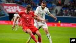 Russia's Aleksandr Sobolev (left) and Iraq's Ali Adnan challenge for the ball during the international friendly soccer match in St.Petersburg, Russia, on March 26.