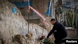 Presidenti ukrainas, Volodymyr Zelensky, duke vendosur lule në kujtim të viktimave të sulmeve të fundit ruse në Kiev. 