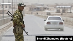 A Tajik frontier guard stands on a bridge to Afghanistan across the Panj River at the Panji Poyon border outpost, south of Dushanbe.