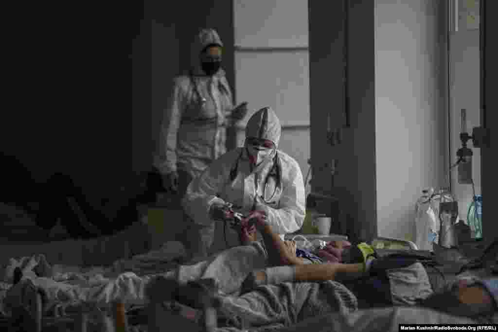 A medic checks a patient in a hospital that is overcrowded with COVID-19 patients in Lviv, Ukraine, on April 6.&nbsp;