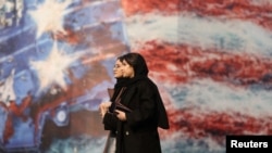 دو زن جوان ایرانی در حال عبور از یک بیلبورد بزرگ تبلیغاتی جمهوری اسلامی در میدان ولیعصر تهران پس از فروکش کردن اعتراضات خونین دی‌ماه ۱۴۰۴