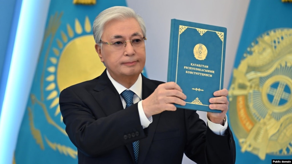 президент Касым-Жомарт Токаев держит Конституцию Казахстана