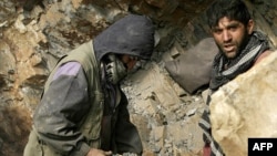 Afghan miners drill into rock in a makeshift emerald mine (file photo).