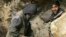 Afghan miners drill into rock in a makeshift emerald mine (file photo).