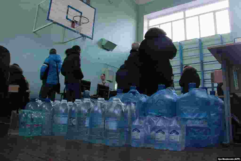 Bottled water is brought into a hall for residents following the explosion.