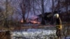 A rescue worker walks past DHL cargo plane wreckage at the crash site near Vilnius International Airport on November 25.