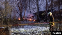 A rescue worker walks past DHL cargo plane wreckage at the crash site near Vilnius International Airport on November 25.