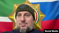 Апти Алаудинов на фоне флага спецназа "Ахмат"