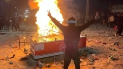 A protester makes a victory sign next to a fire in the midst of unrest in Abdanan, Iran, on January 6.