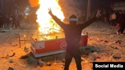Demonstrant pokazuje znak pobjede ispred vatre usred nereda u gradu Abdanan, provincija Ilam, 6. januara.
