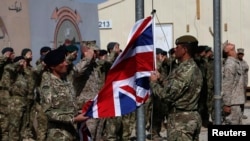 British troops lower the Union Flag during a ceremony marking the end of operations for U.S. Marines and British combat troops in Helmand Province on October 26, 2014.