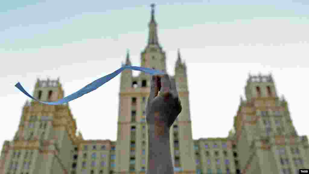 A Russian opposition activist waves a white ribbon on Kudrinskaya Square in central Moscow. (ITAR-TASS/ Sergei Karpov)