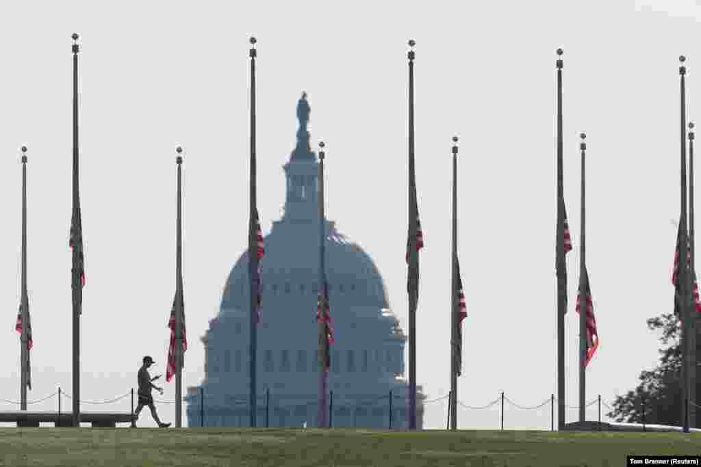 Një vizitor ecën pranë Monumentit të Uashingtonit teksa flamujt amerikanë janë ulur në gjysmështizë për të nderuar viktimat e 11 shtatorit. Uashington DC, 11 shtator, 2021.&nbsp; &nbsp;