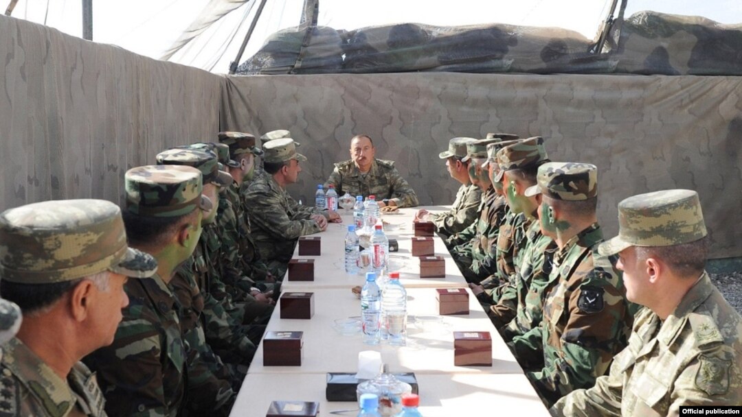 Azerbaijani President Ilham Aliyev (center) talks to soldiers serving in the Agdam district east of Nagorno-Karabakh on August 6.