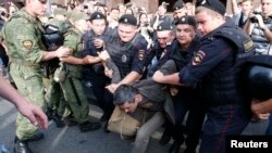 A supporter of Aleksei Navalny is detained by police in central Moscow on July 18.