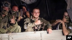Wagner soldiers sit in their vehicle on a street in Rostov-on-Don on June 24. Relatives of Wagner fighters say they are angry, and worried, about what comes next. 