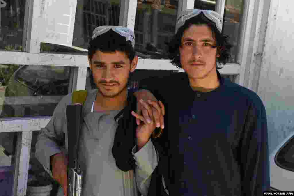 Dy luftëtarë talibanë duke pozuar për një fotografi në distriktin e Kenxhit.