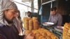 Afghanistan -- A shopkeeper assists customers in buying sweets at a market on the first day of Ramadan in Kabul, 13Sep2007