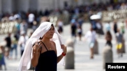 Një grua në Vatikan, gjatë valës të të nxehtit. 19 korrik 2023. 